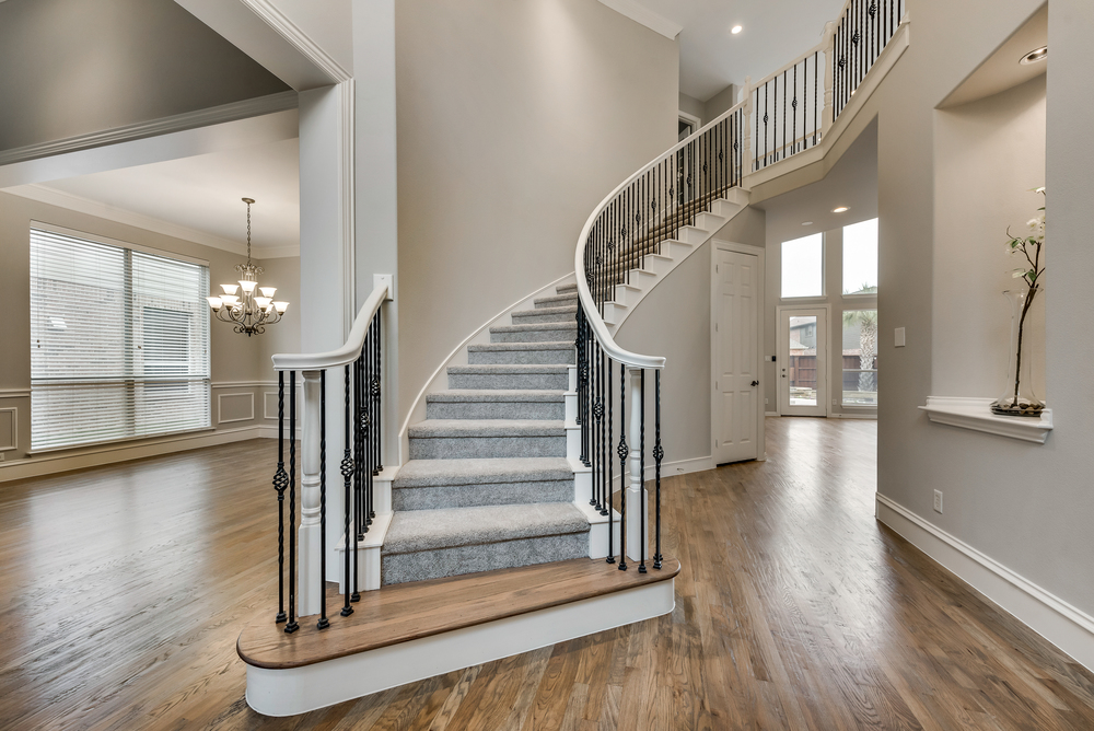    Soaring Entry with Freshly Stained Hardwood Floors and Wrought Iron Staircase 