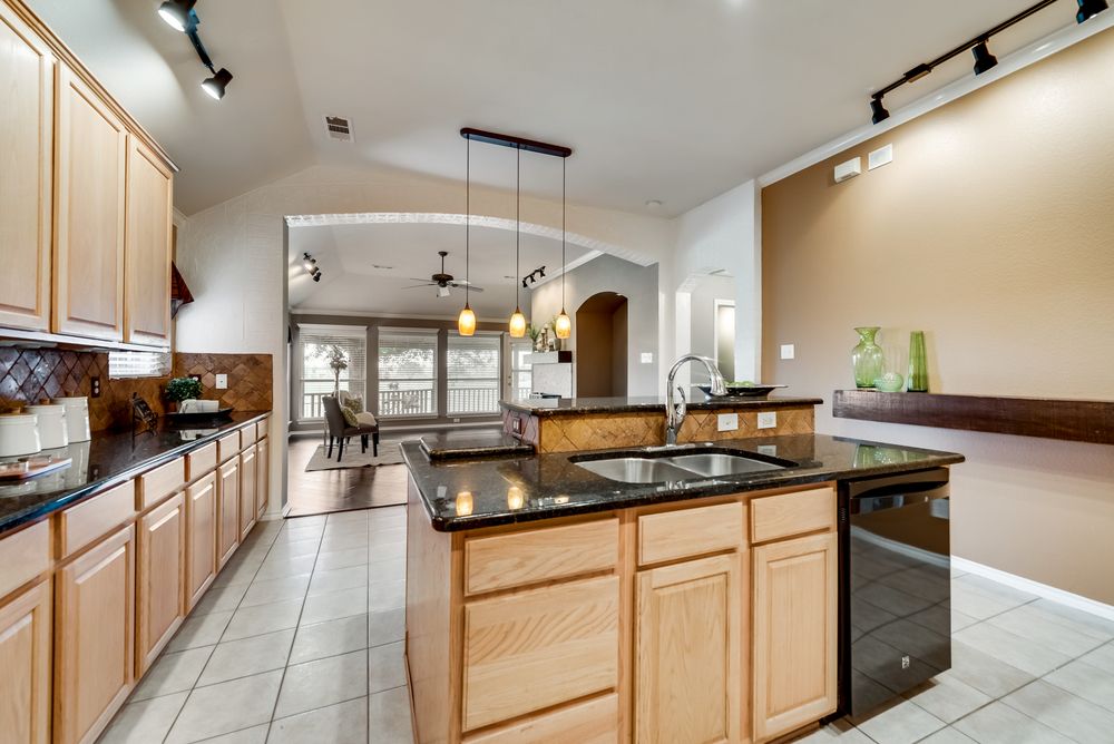    Kitchen features granite countertops tumbled stone backsplash and tile floors 
