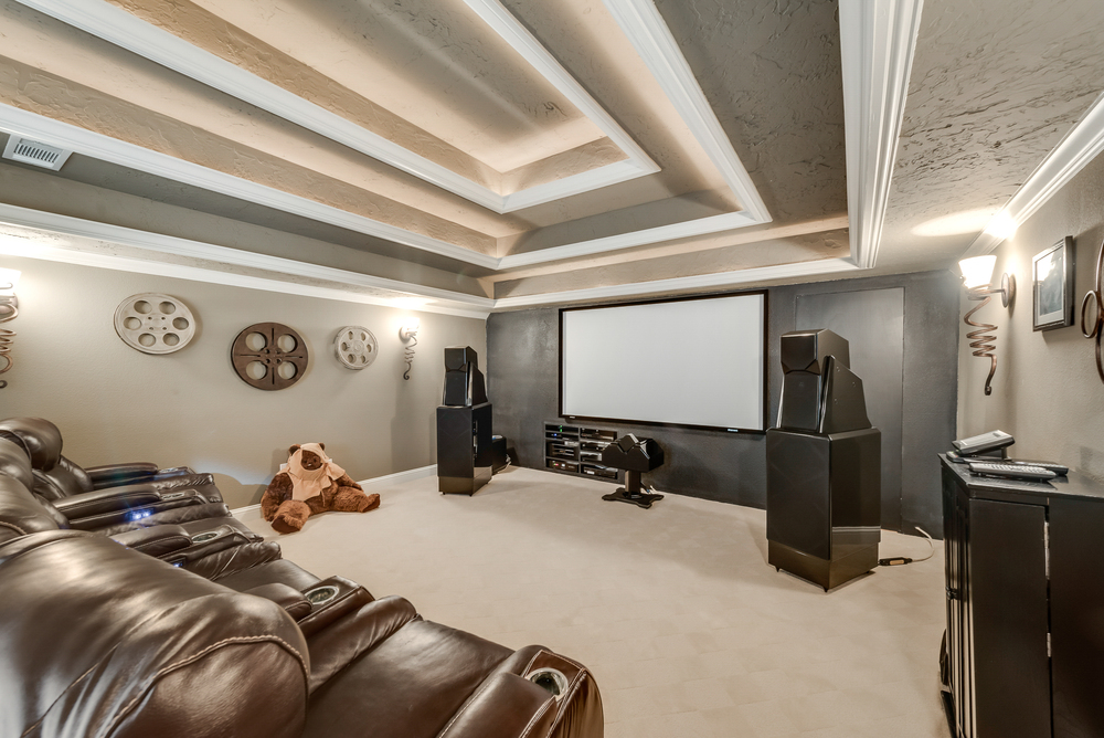    Media Room with Teired Seating Area and Storage Space behind Wall for Screen 