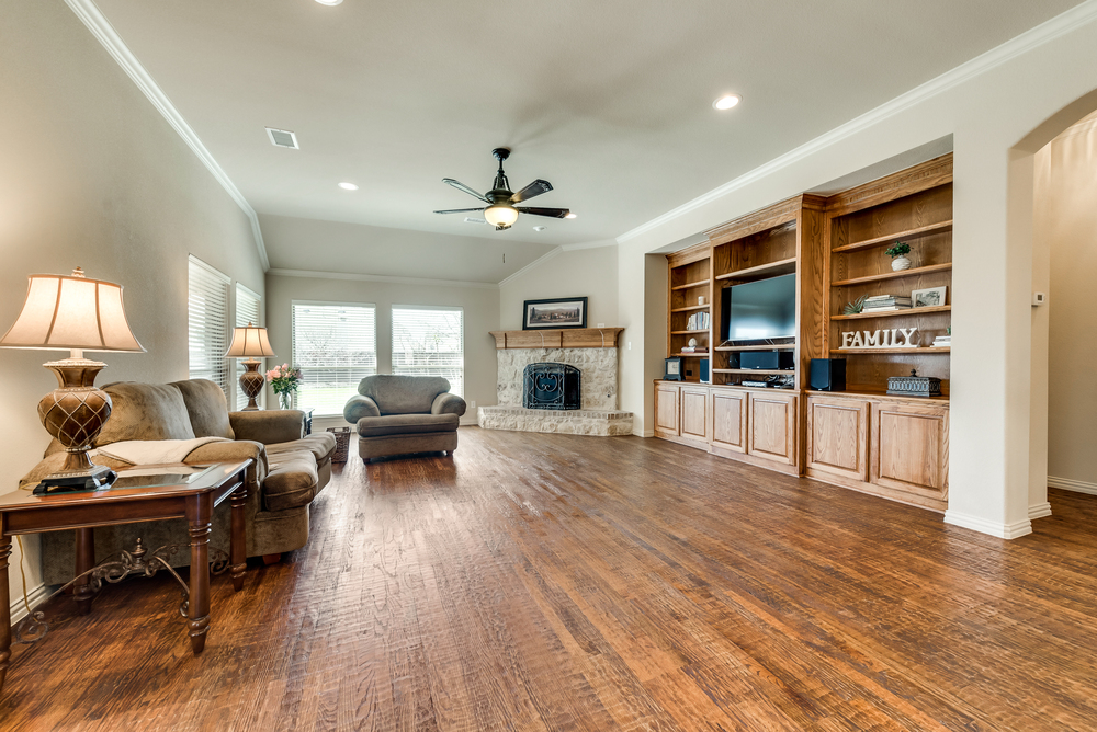    Inviting Family Room features Wall of Built In Cabinetry and Stone Fireplace 