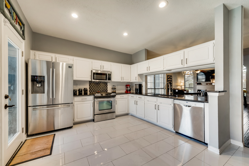    Chef s Kitchen with White Cabinetry Granite Countertops and Stainless Appliances   