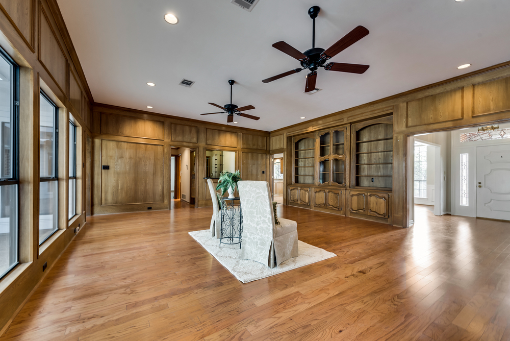    Family Room features Wall of Stunning Built In Cabinetry with Glass Door Details and Wet Bar 